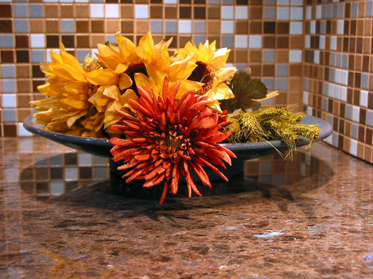 granite countertop with a bowl of colorful flowers